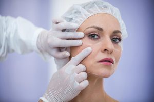doctor examining female patients face cosmetic treatment